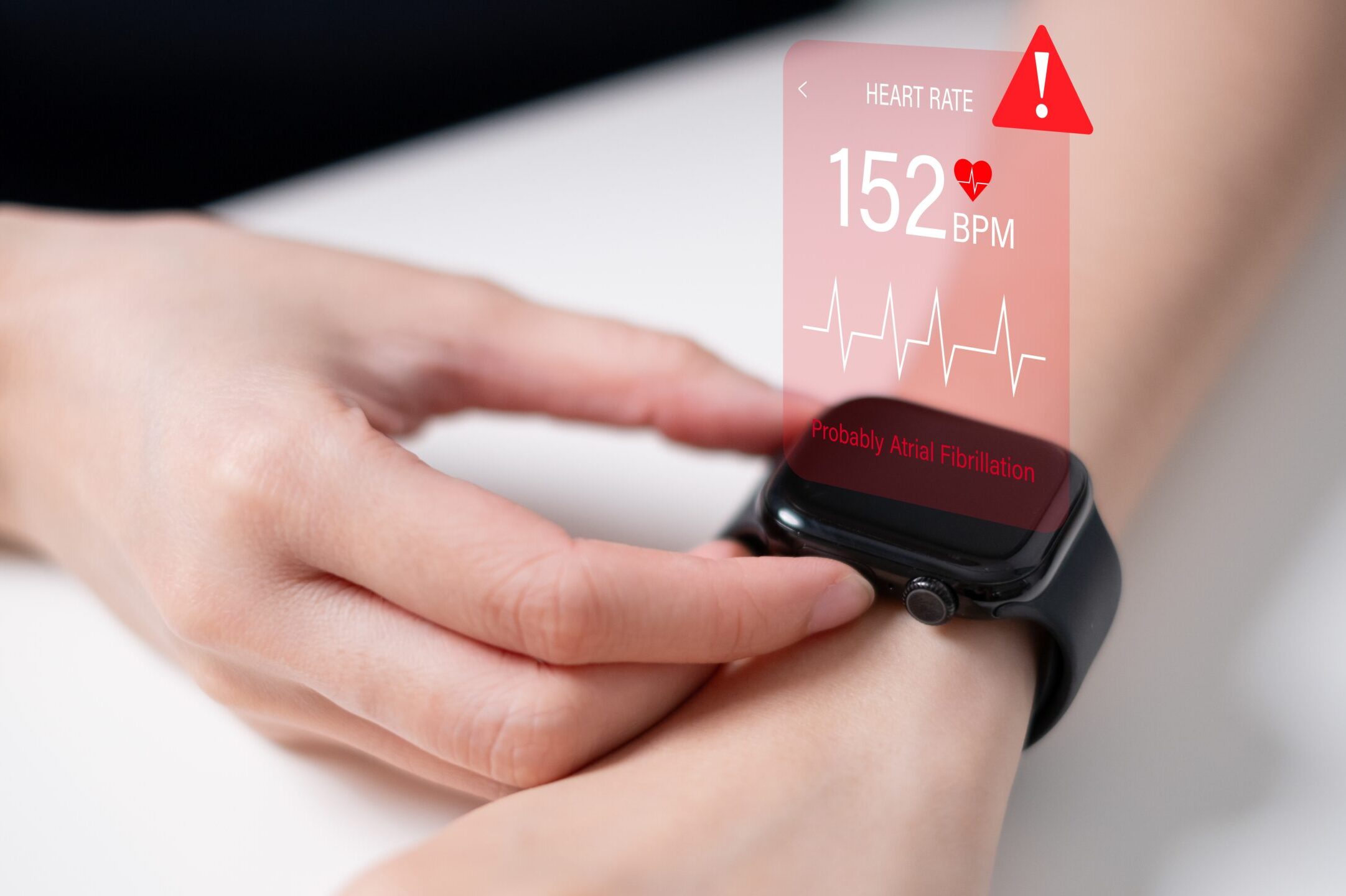 Eine Person überprüft die Herzfrequenz auf einer Smartwatch, die eine erhöhte Herzfrequenz von 152 BPM und einen Warnhinweis auf Vorhofflimmern anzeigt.
