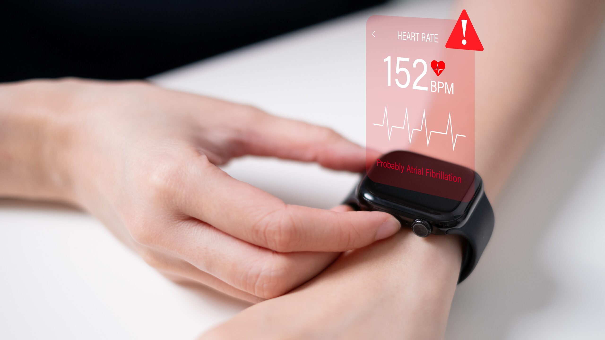 Eine Person überprüft die Herzfrequenz auf einer Smartwatch, die eine erhöhte Herzfrequenz von 152 BPM und einen Warnhinweis auf Vorhofflimmern anzeigt.